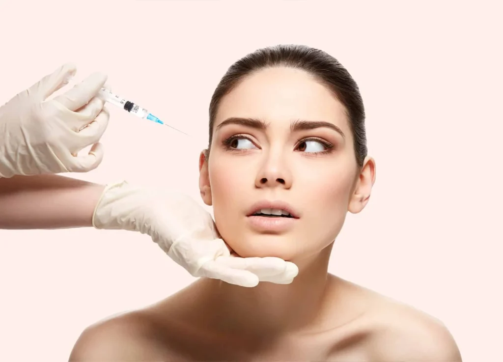 A woman with a concerned expression looks to the side as a gloved hand holds a syringe near her face. The background is a soft pastel color, creating a clinical, contemplative atmosphere.